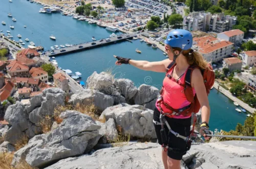 A woman enjoys the view from the top of Via ferrata Omis